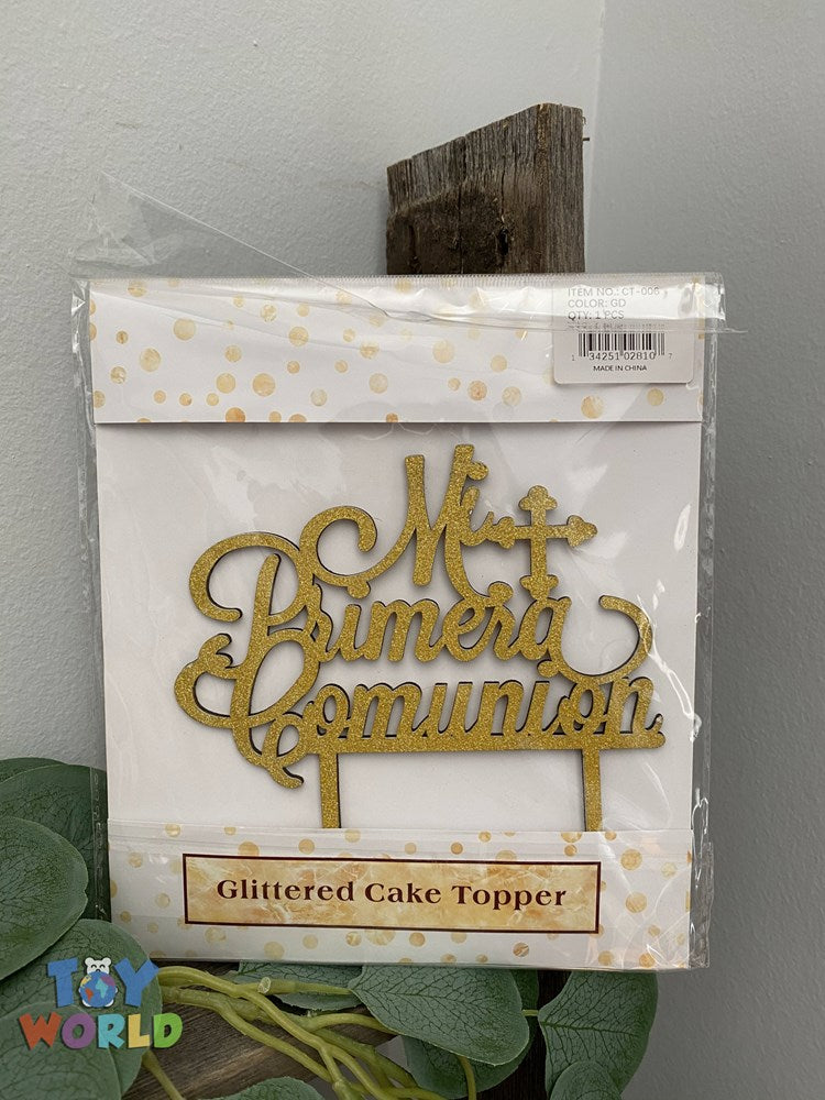 Gold glittered cake topper with cursive script reading "Mi Primera Comunion" and star accents.