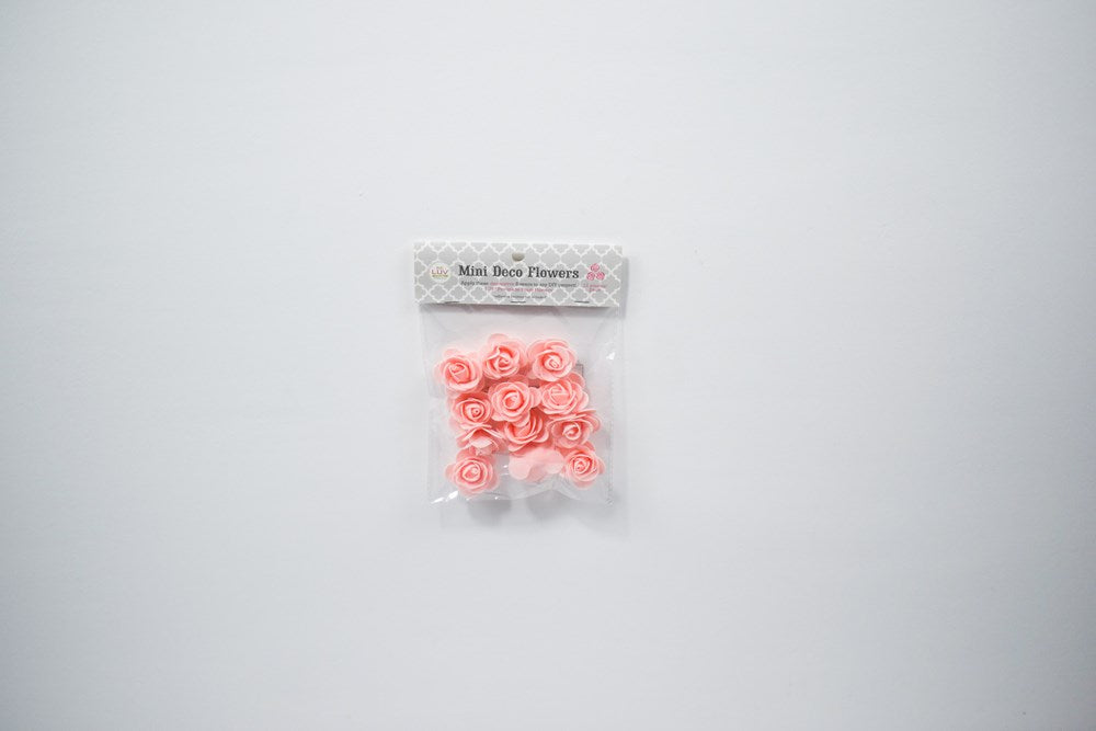 Twelve small blush pink foam flowers with delicate petal shapes in clear plastic packaging.