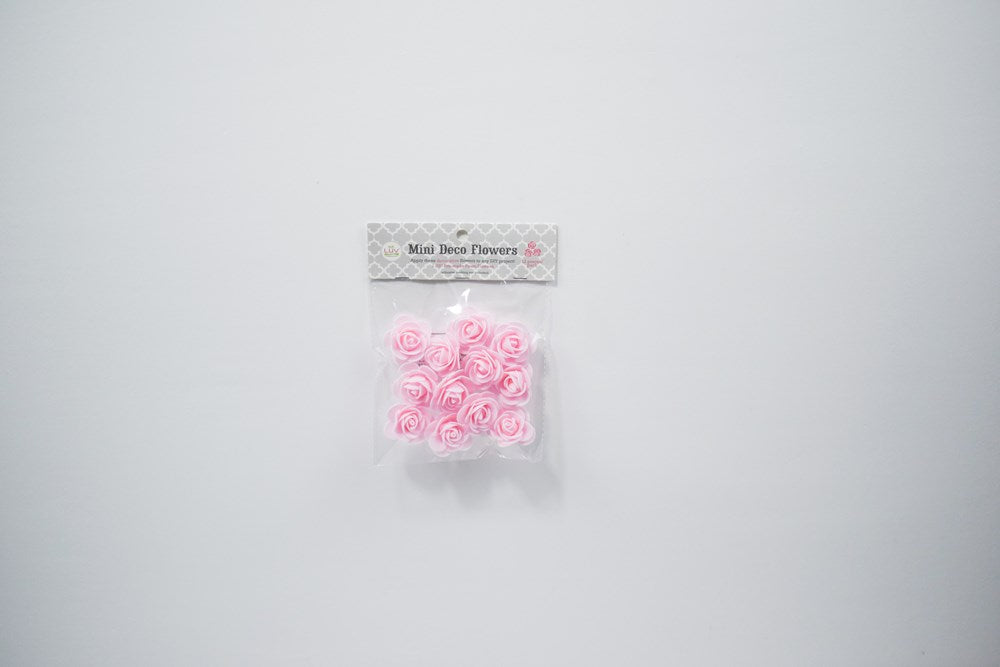 Set of twelve small light pink foam flowers with rounded petals for party decoration.