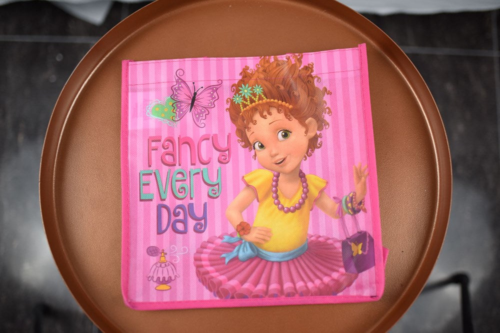 Pink non-woven tote bag featuring Fancy Nancy character in a tutu and tiara with colorful text and butterfly accents.
