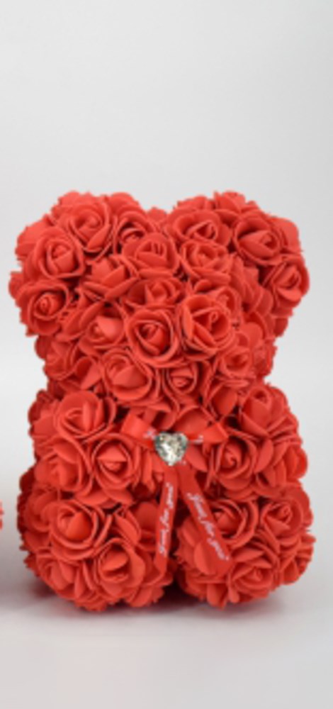 9.5in teddy bear made of red foam roses with a small silver heart charm on a red ribbon bow.
