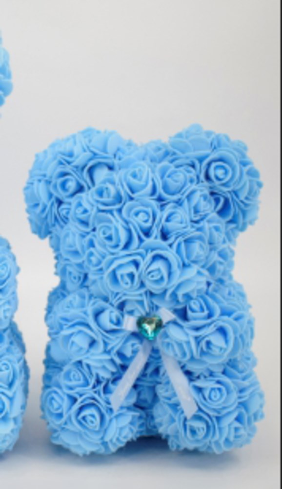 Sky blue teddy bear made of small foam roses with a blue ribbon and a pearl in the center.