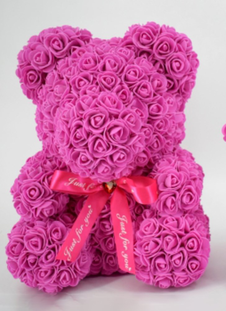 15in teddy bear made of fuchsia foam roses with a shiny pink ribbon tied around its neck.