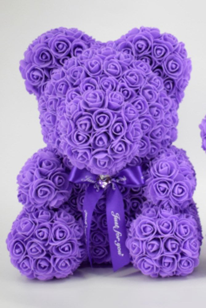 Purple teddy bear made entirely of small foam roses with a purple ribbon around its neck.