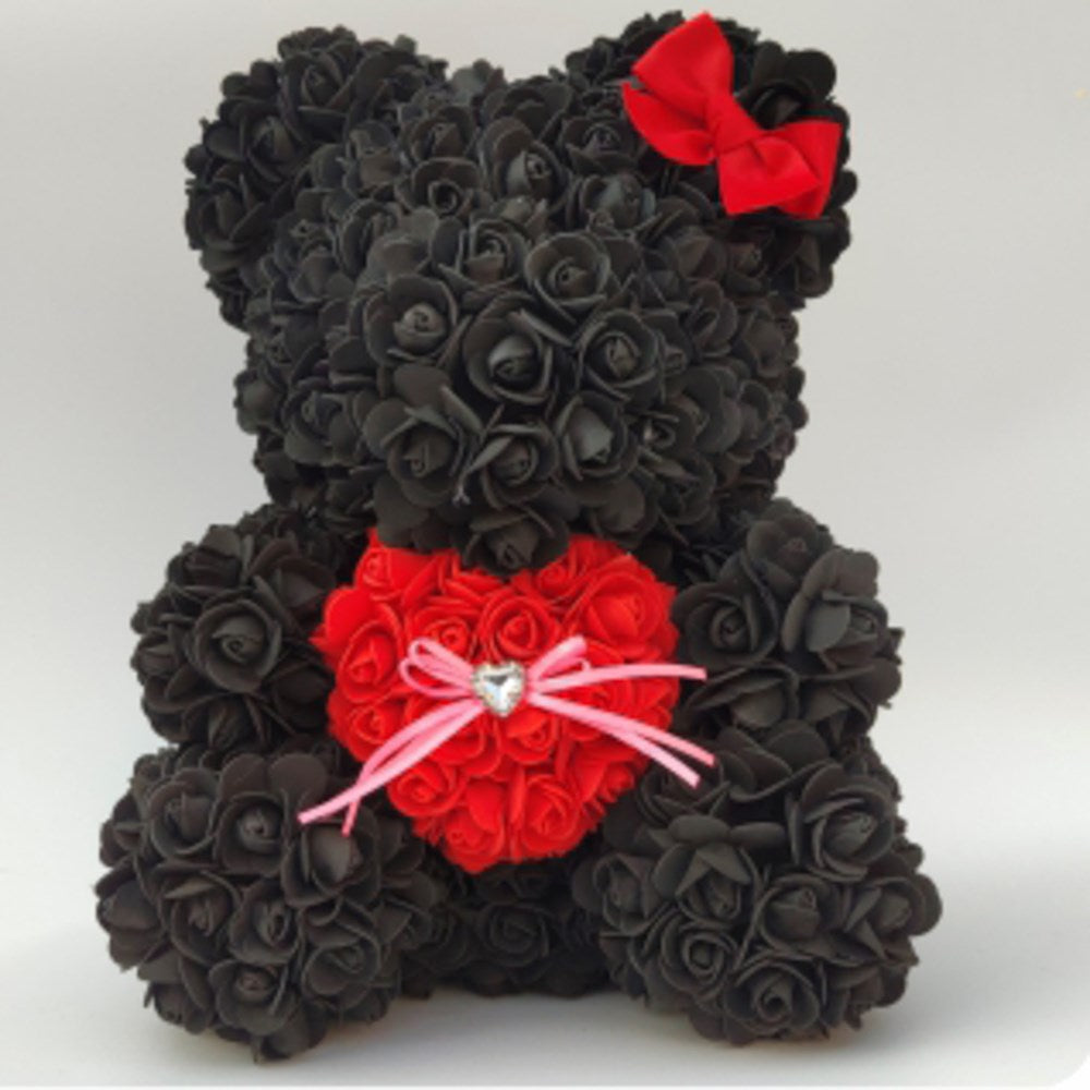 15-inch black bear made of foam roses holding a red heart with pink whiskers and a white nose, adorned with a red bow on its