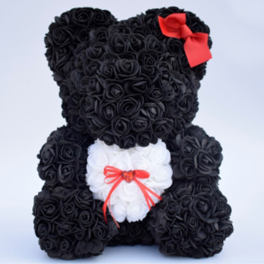 Black teddy bear made of foam roses with a white heart on the chest, adorned with red bows.