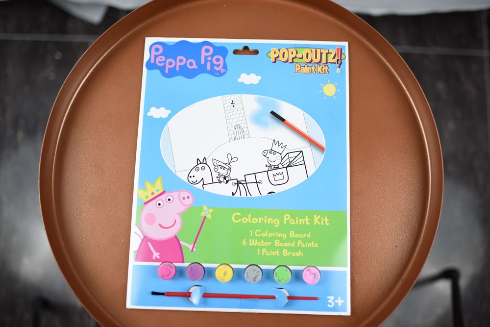 Peppa Pig coloring paint kit with five small paint pots, a brush, and a cardboard playset display in blue packaging.