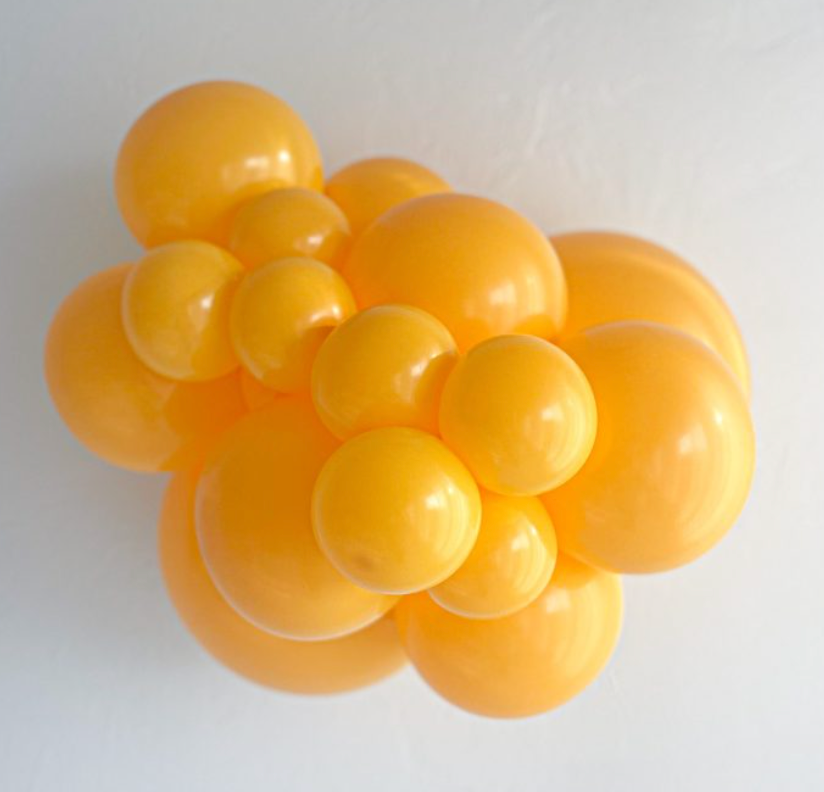 Cluster of shiny goldenrod yellow latex balloons in various sizes with a smooth surface.