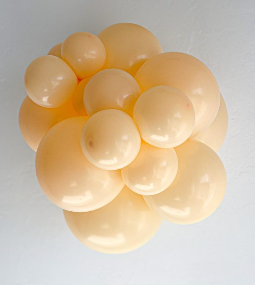 Cluster of large, round, blush-colored latex balloons with a smooth, glossy finish.