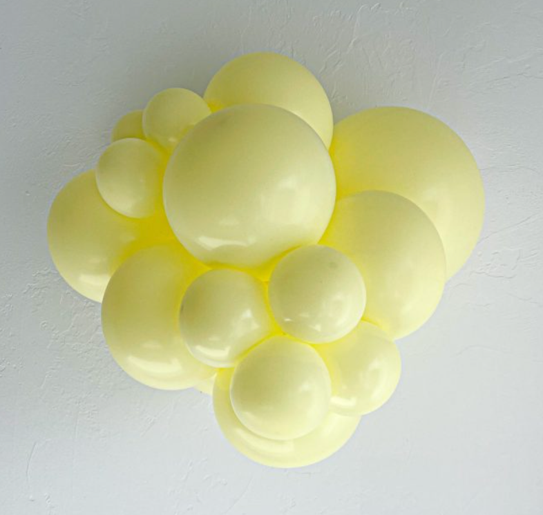 Cluster of pale yellow latex balloons in varying sizes forming a decorative arrangement.