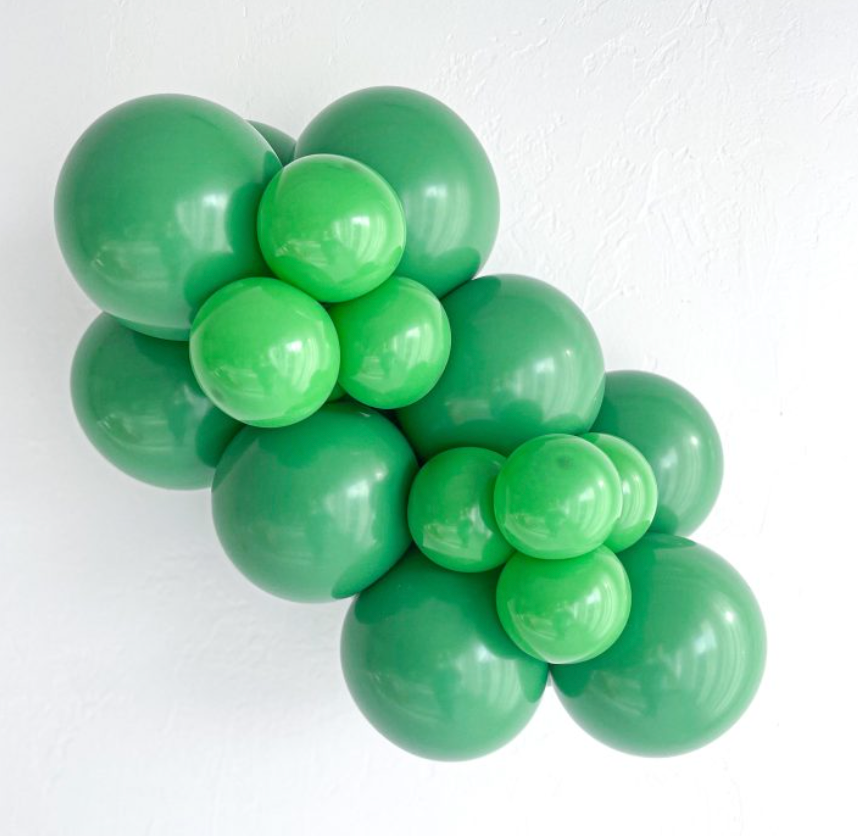 Cluster of shiny green latex balloons in varying sizes, arranged in a decorative bunch.