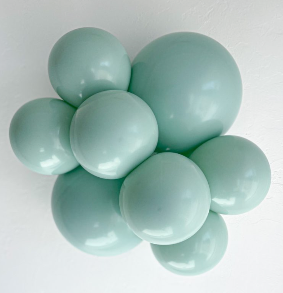 Cluster of shiny, mint green latex balloons inflated to various sizes.