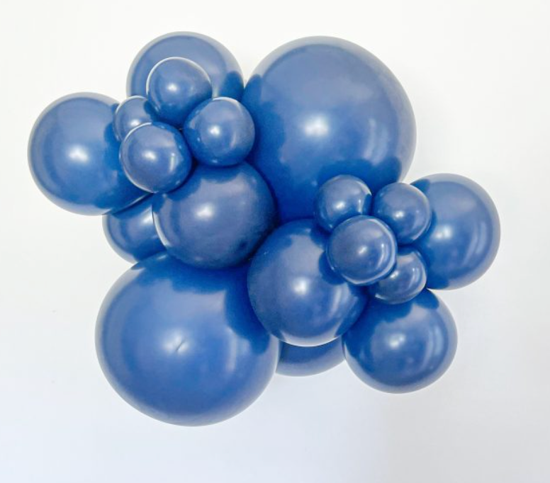 Cluster of navy blue latex balloons in various sizes inflated and arranged closely together.