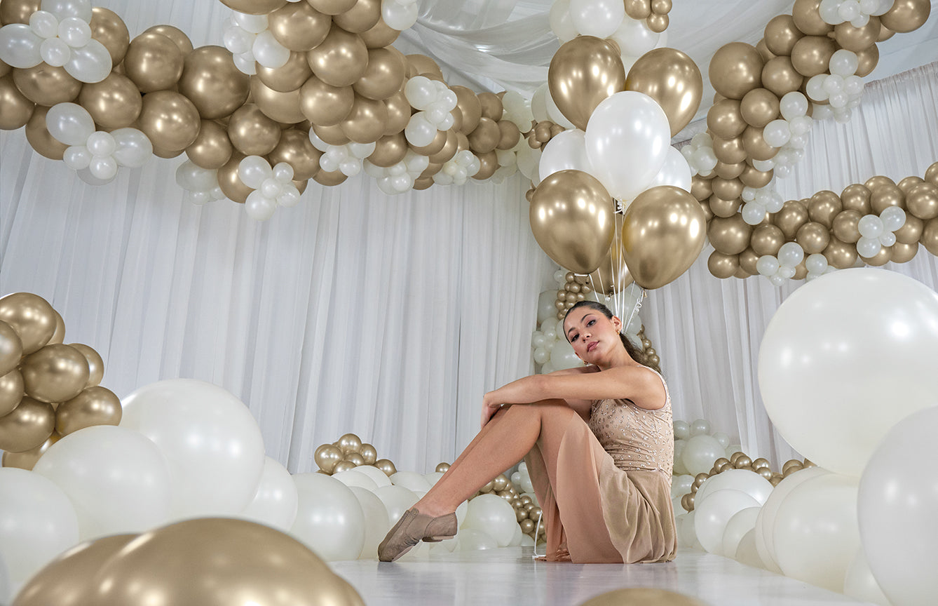 Glossy gold and white 5-inch latex balloons with a metallic silk dust finish, arranged in clusters and garlands.