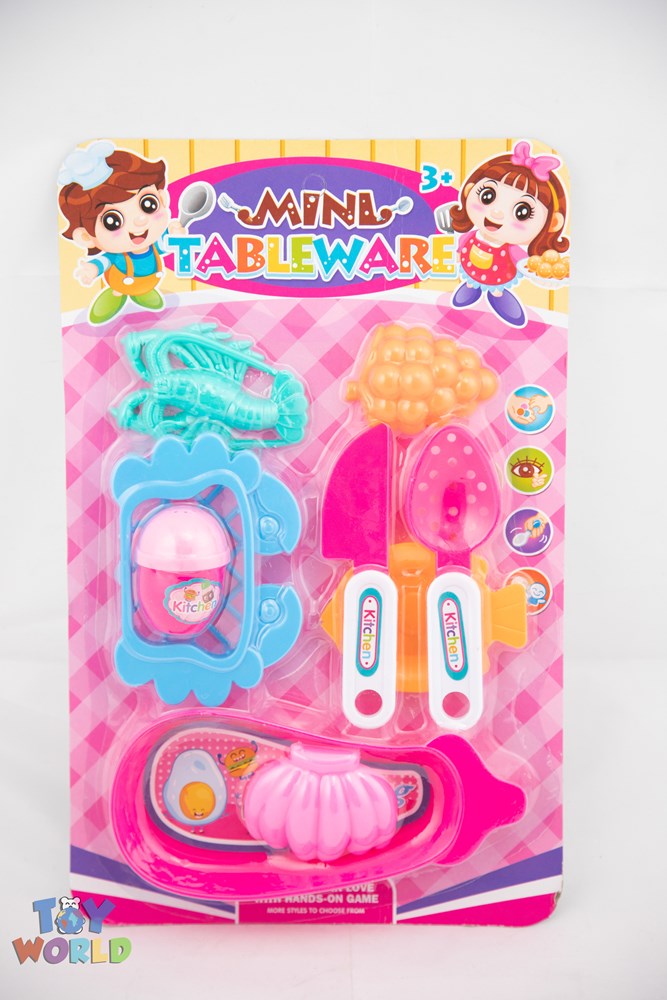 Colorful plastic cooking toy set with pink tray, utensils, and food shapes on a blister card.