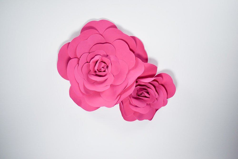 Two hot pink decorative wall flowers in 12-inch and 16-inch sizes with layered petals.