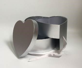 Gray heart-shaped gift box with matching lid and white ribbon, open to show interior.