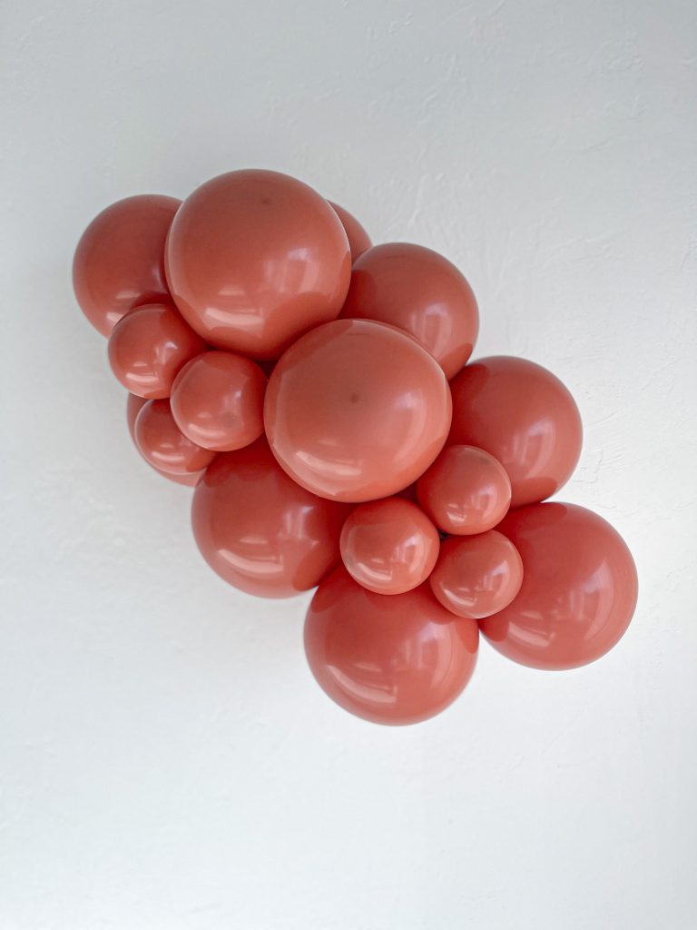 Tuftex Burnt Orange latex balloon color cluster showing the shade across multiple balloon sizes