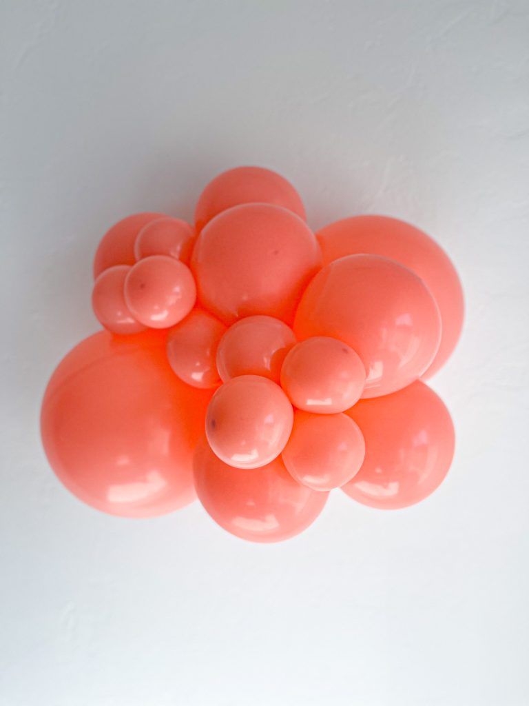 Tuftex Coral latex balloon color cluster showing the shade across multiple balloon sizes