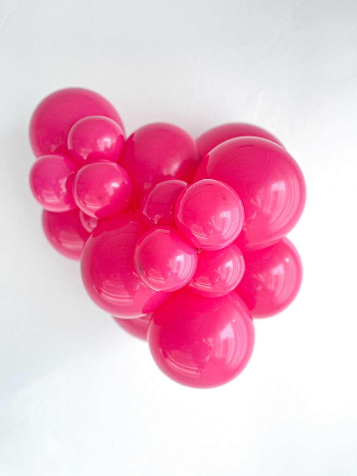 Tuftex Hot Pink latex balloon color cluster showing the shade across multiple balloon sizes