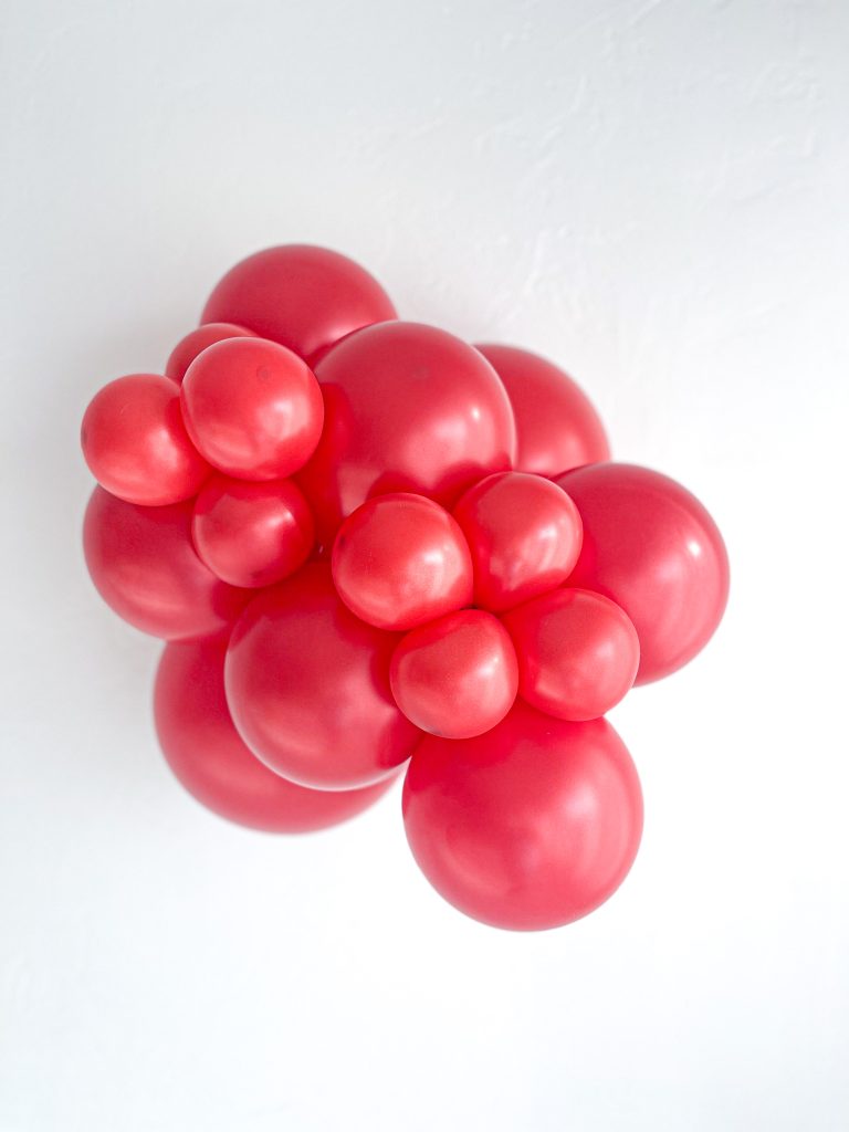 Tuftex Pearlized Starfire Red latex balloon color cluster showing the shade across multiple balloon sizes