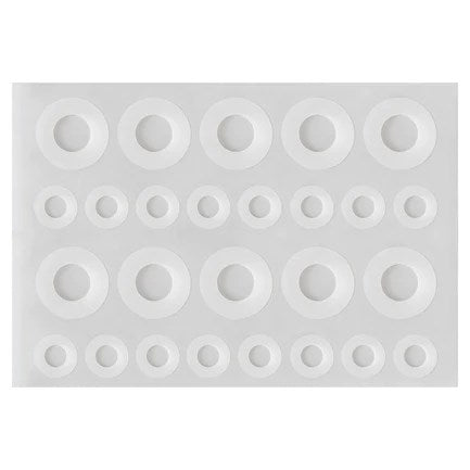 White circular adhesive tab guards in three different sizes arranged on a rectangular backing sheet.