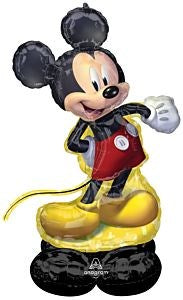 Foil balloon shaped like Mickey Mouse in red shorts, yellow shoes, and black ears standing on black base.