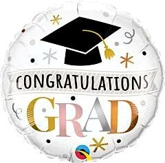 Round silver foil balloon with black graduation cap and gold tassel, "Congratulations Grad" text in black, gold, pink, and.
