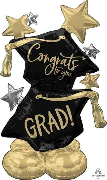 Black graduation cap-shaped foil balloon with gold "Congrats to you" and "GRAD!" text, gold and silver star accents, and.