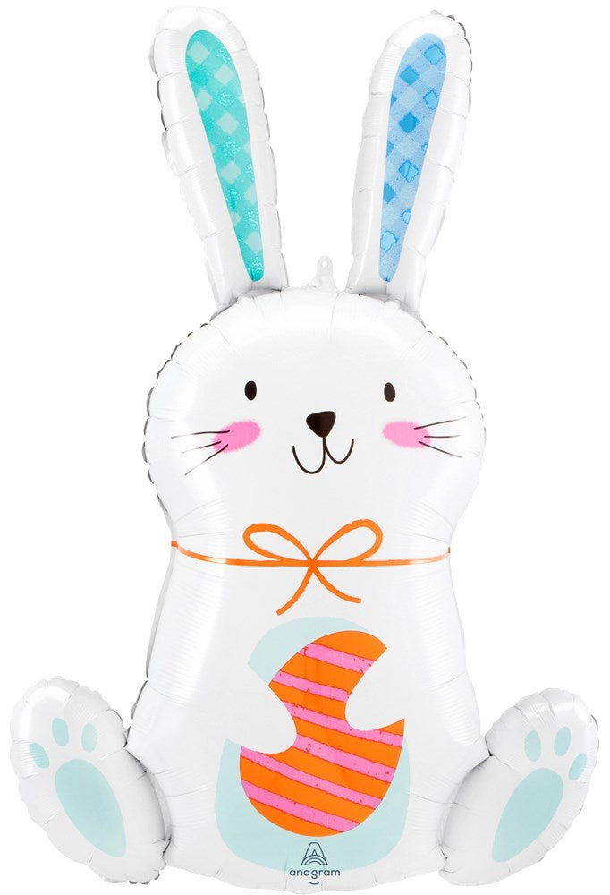 White foil balloon shaped like a sitting bunny with blue polka-dot ears, pink cheeks, and holding a decorated Easter egg.