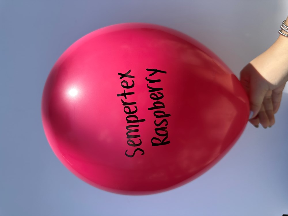Glossy raspberry pink latex balloon inflated, round shape, Sempertex brand text printed in black.
