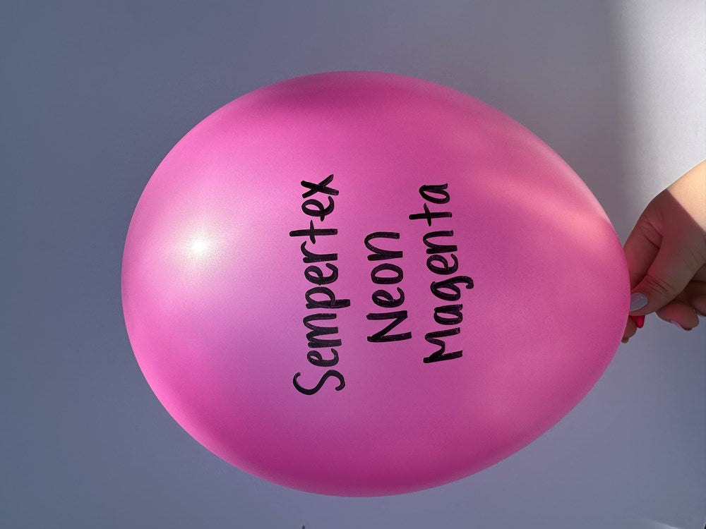 Bright neon magenta latex balloon inflated to 11 inches with Sempertex branding in black text.