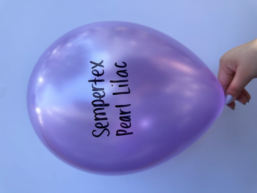 Glossy pearl lilac 11-inch latex balloon with black "Sempertex Pearl Lilac" text, held by hand.