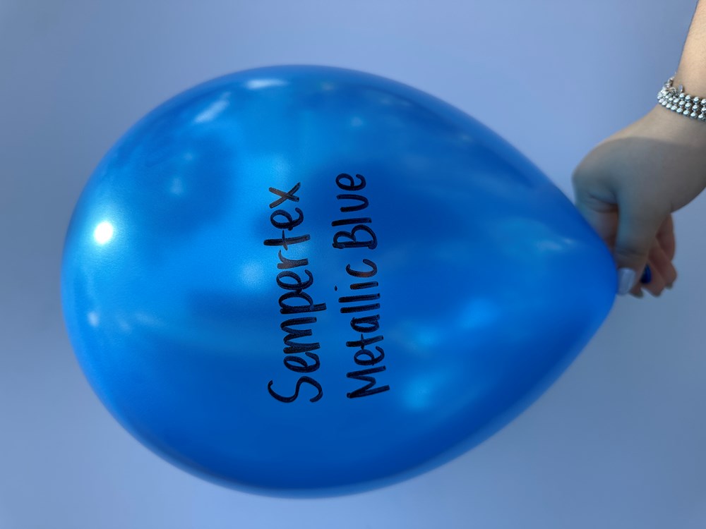 Glossy metallic blue 11-inch latex balloon with black "Sempertex Metallic Blue" text, held by hand.