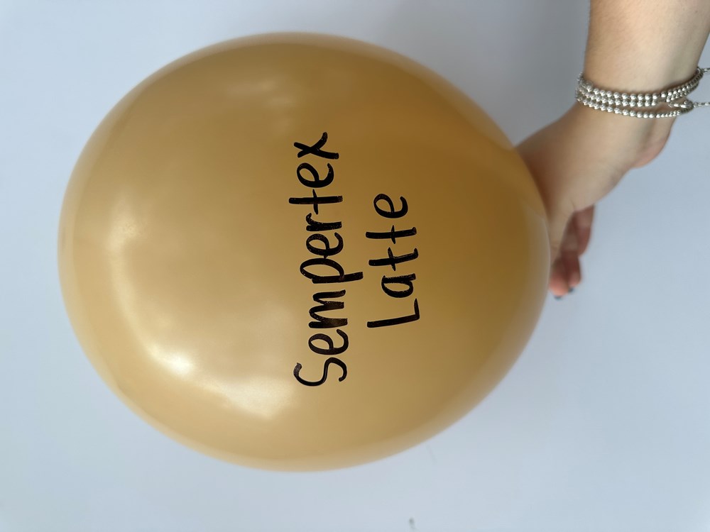 Latte brown round latex balloon with Sempertex Latte text, held by hand against white background.