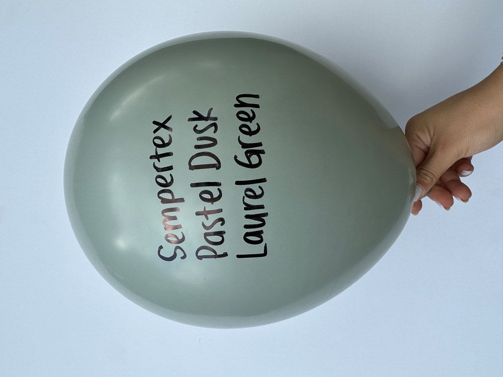 Matte pastel dusk laurel green latex balloon inflated, smooth round shape, hand holding edge.