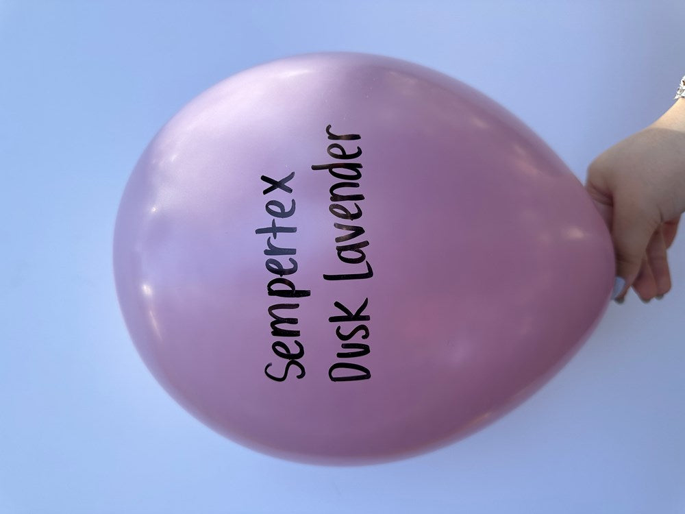 Light purple 11-inch latex balloon with Sempertex Dusk Lavender text, held by hand.
