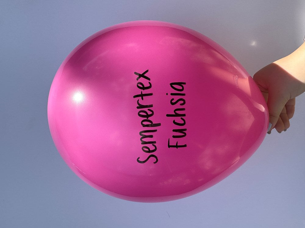 Bright fuchsia 18-inch latex balloon with Sempertex logo held against a clear sky.