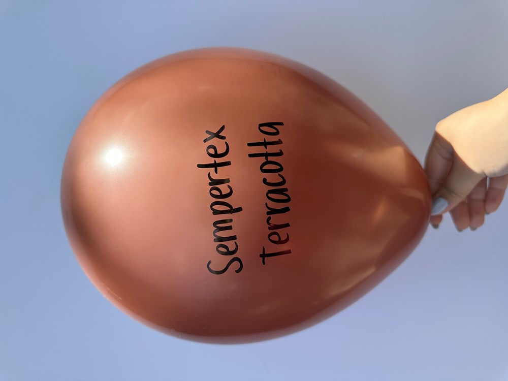 18-inch round terracotta latex balloon with Sempertex Terracotta text, held against blue sky.