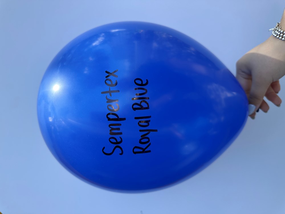 Glossy royal blue latex balloon inflated, 36 inch, with black "Sempertex Royal Blue" text, held by hand.