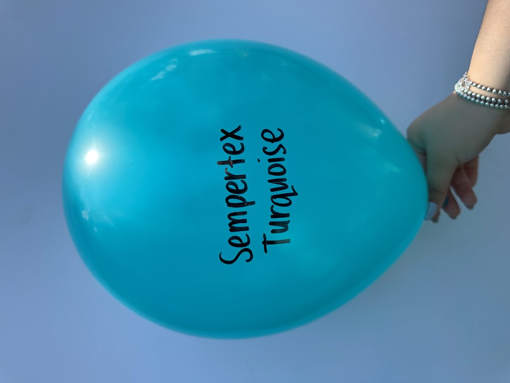 Large round turquoise blue latex balloon with Sempertex Turquoise text, held by hand.