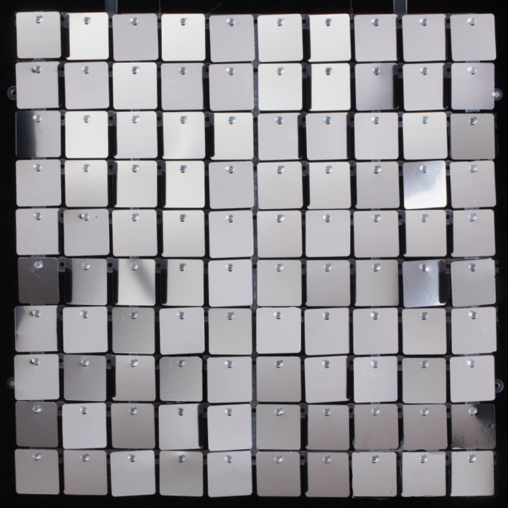 Silver square sequin wall panel with reflective, hinged sequins creating a shimmering mosaic effect.