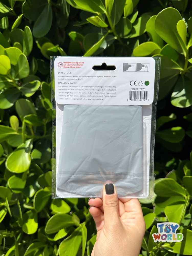 White 26-inch starburst-shaped foil balloon in sealed packaging held against green leaves background.