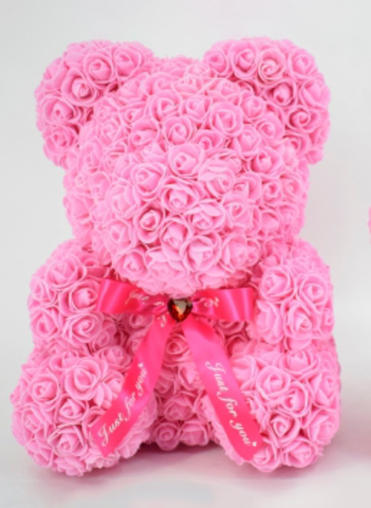 Pink teddy bear made entirely of foam roses with a shiny satin bow around its neck.