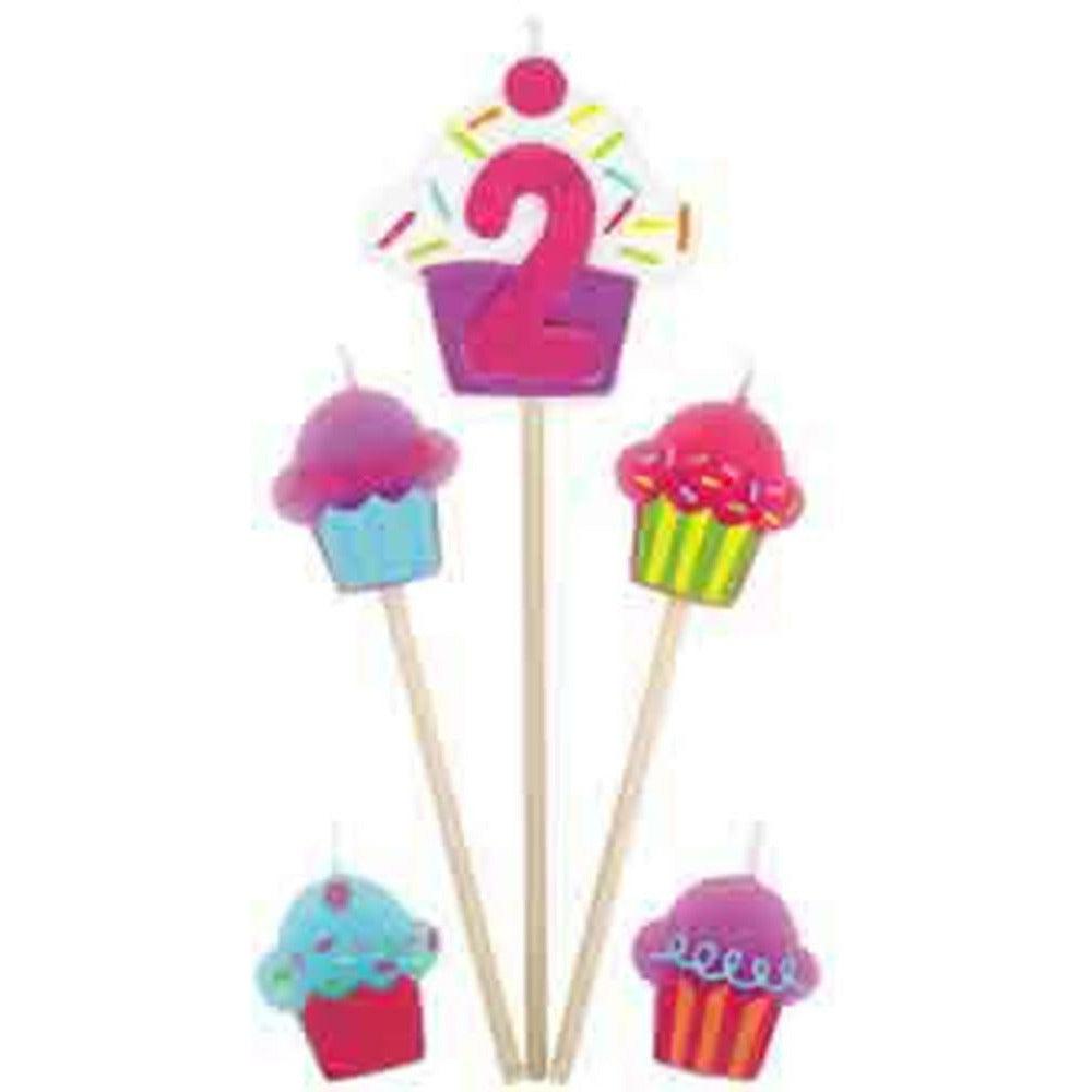 Pink number 2 cupcake candle with colorful sprinkles and four small cupcake-shaped candles on wooden picks.