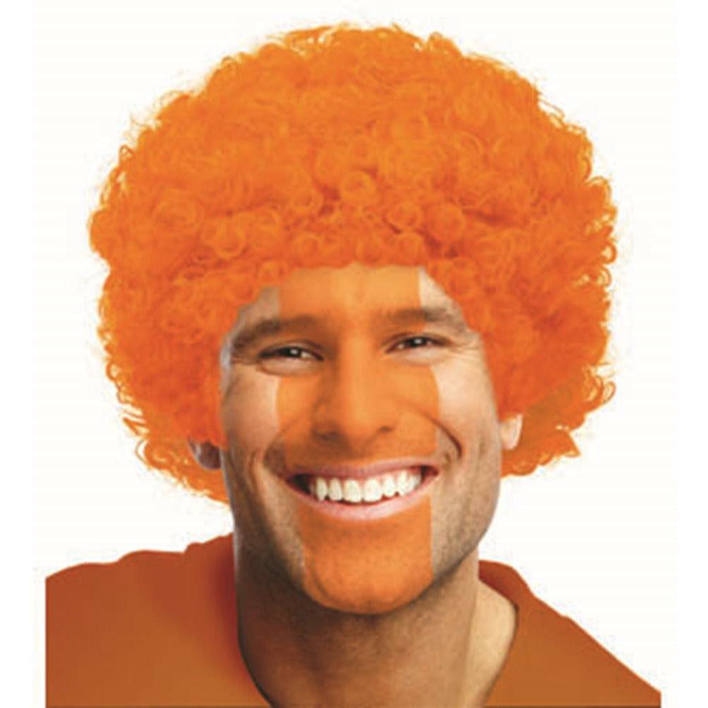 Bright orange curly afro wig on smiling man with light skin tone and brown eyes.