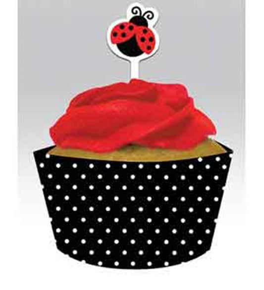 Black cupcake wrapper with white polka dots topped with red frosting and a red ladybug pick decoration.
