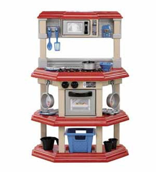 Compact toy kitchen set with red countertops, beige frame, built-in oven, stove, microwave, and hanging utensils.