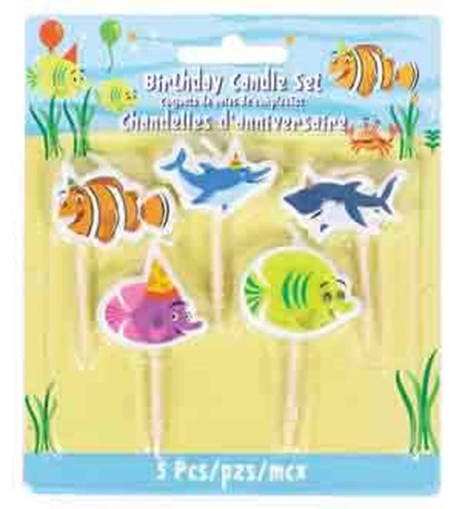 Set of five colorful ocean animal birthday toothpick candles with clownfish, shark, and other fish designs on a beach-themed .