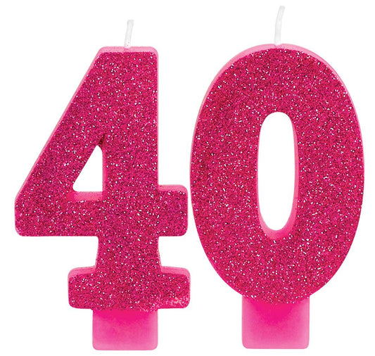Pink-gold glitter numeral candles shaped as 4 and 0 with white wicks and pink holders.